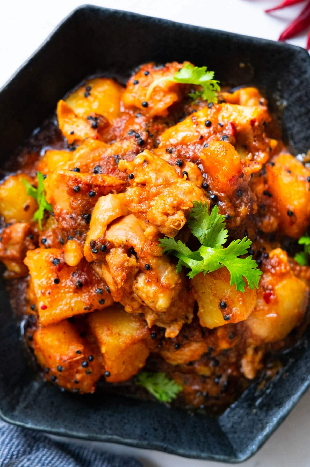 Portuguese devil's curry served in a shallow plate with cilantro on top.