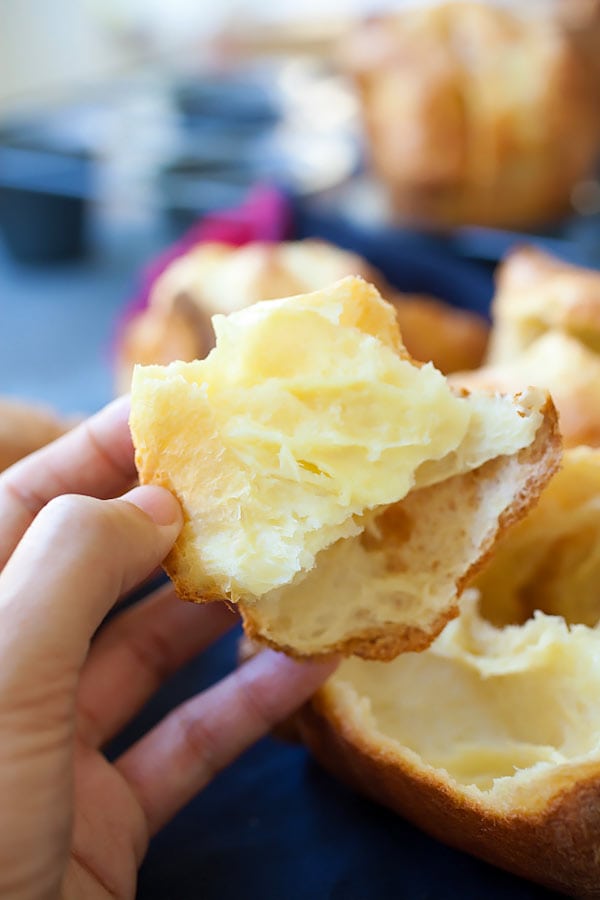 American popover recipe held in a hand, made with few ingredients and so easy to make.