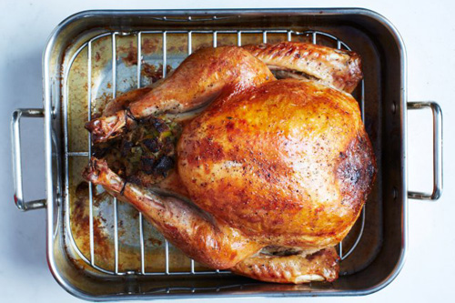 Whole roasted turkey on a baking tray.