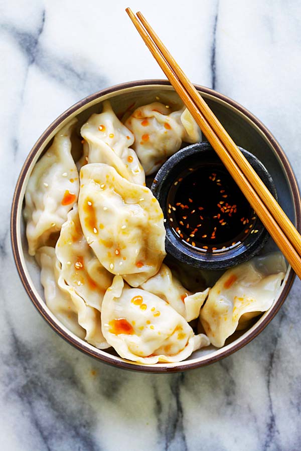 Easy homemade Chinese Pork Shrimp and Napa Cabbage Dumplings in a bowl with a side of dumpling dipping sauce.