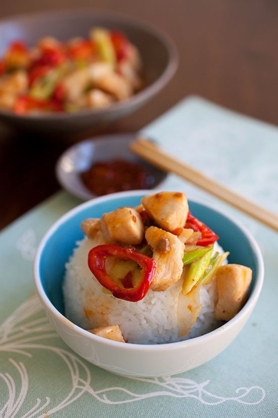 Homemade Szechuan stir-fry chicken on top of rice in a bowl.