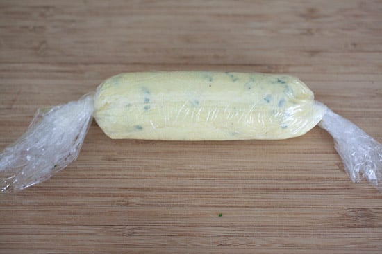 Garlic butter made at home wrapped in plastic wrap and ready to freeze.