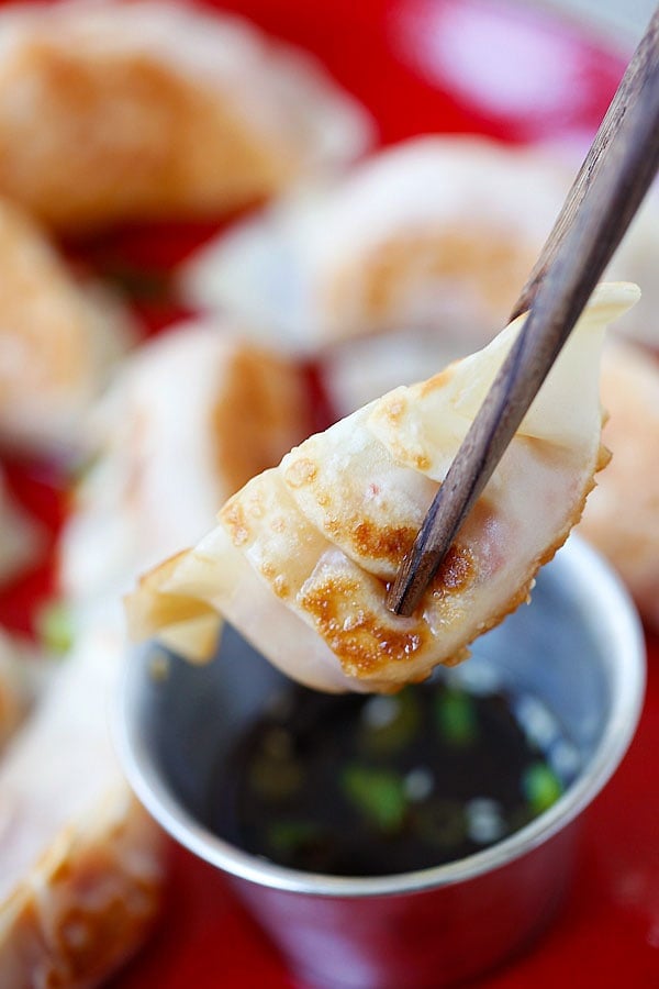 Kimchi Dumplings picked with a pair of chopsticks.