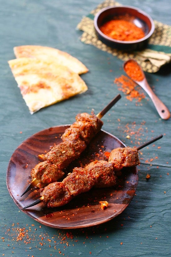  Brochettes d'agneau avec marinade aux épices faciles dans une assiette en bois.