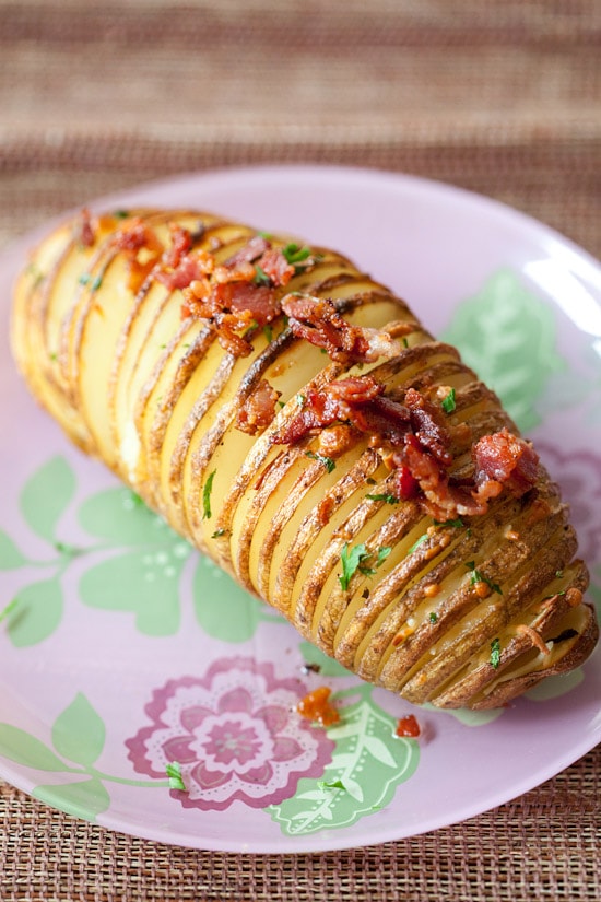 Easy gratin Hasselback Potatoes with bacon & parmesan on a plate.