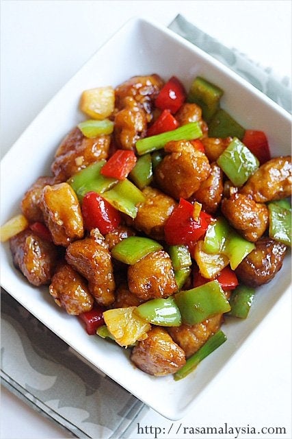 Glistening sweet and sour pork with green peppers and pineapple in a bowl made with homemade sweet and sour sauce.