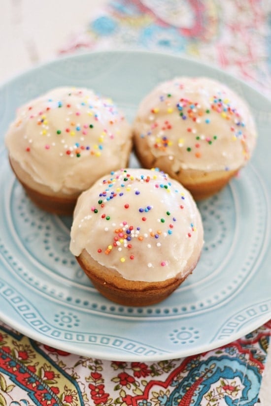 Easy and cute mini glazed doughnut muffins coated with colorful sprinkles.