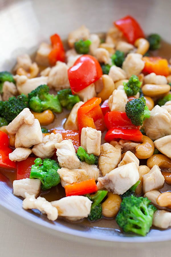 Honey cashew chicken stir fry with broccoli, bell peppers, cashew nuts in brown Asian honey sauce in a skillet.