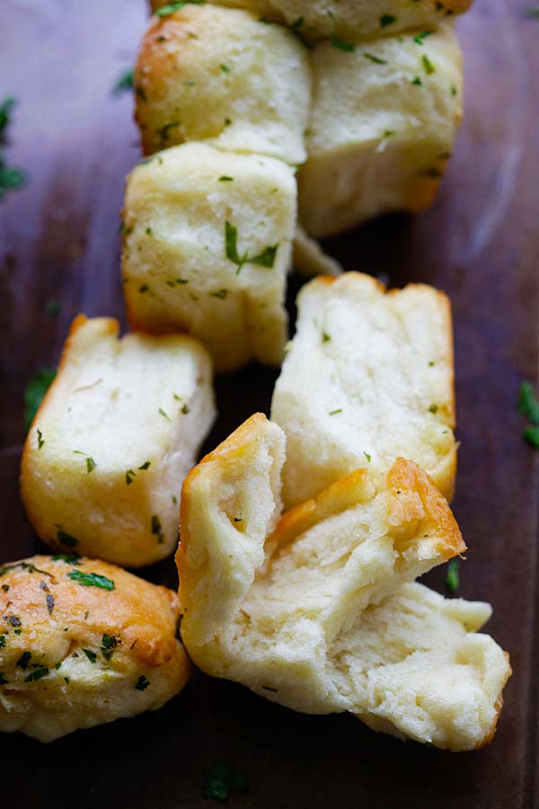 Pull apart garlic bread teared on table.
