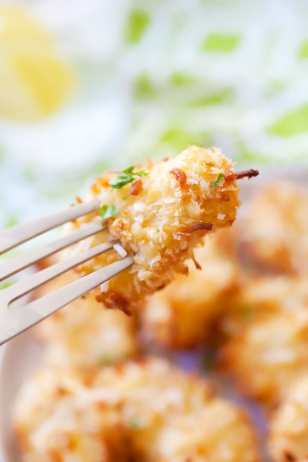 Crispy golden Parmesan baked chicken nuggets poked with a fork.