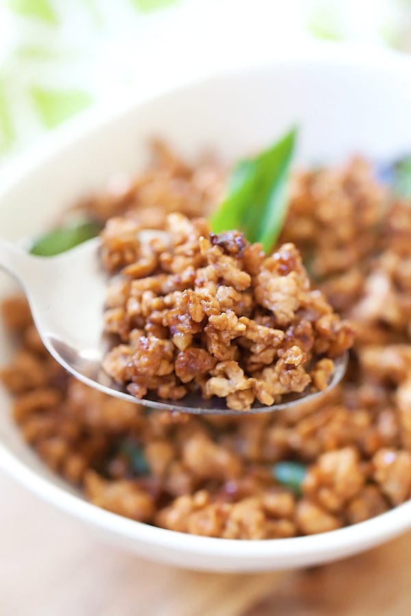 Spicy basil chicken made from a thai basil chicken recipe in bowl, garnished with fresh basil.