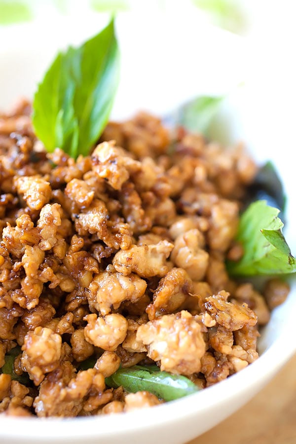 Basil chicken recipe made with delicious Thai basil leaves in bowl with spoon.