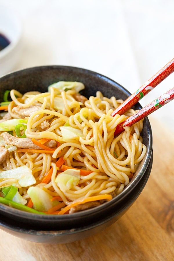 Popular Yakisoba or Japanese fried noodles in a bowl with a pair of red chopsticks.