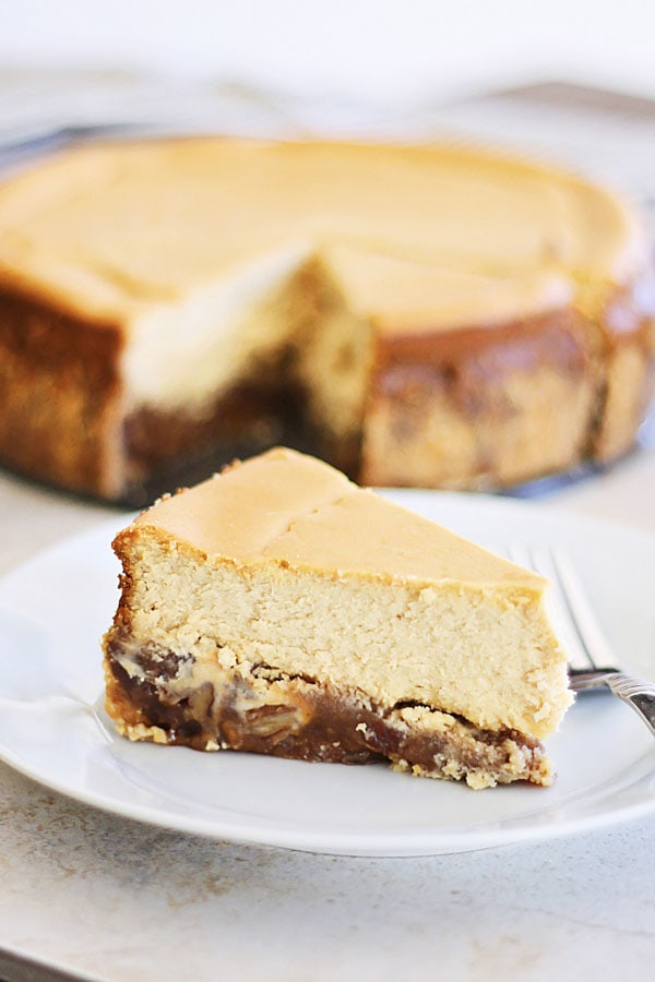 A piece of easy Pecan Pie Cheesecake served in a plate with a fork.