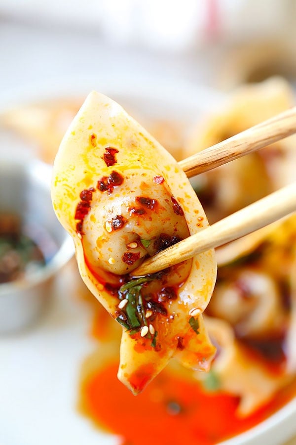 Les wontons à l'huile rouge du Sichuan cueillis avec une paire de baguettes.