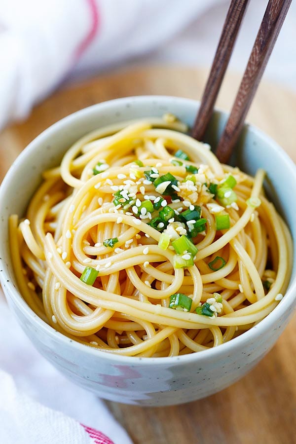 Asian style spaghetti noodles garlic sesame dressing in a bowl.