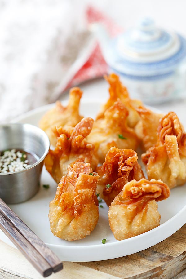 Asian delicious chicken wontons in a plate, complete with dipping sauce.