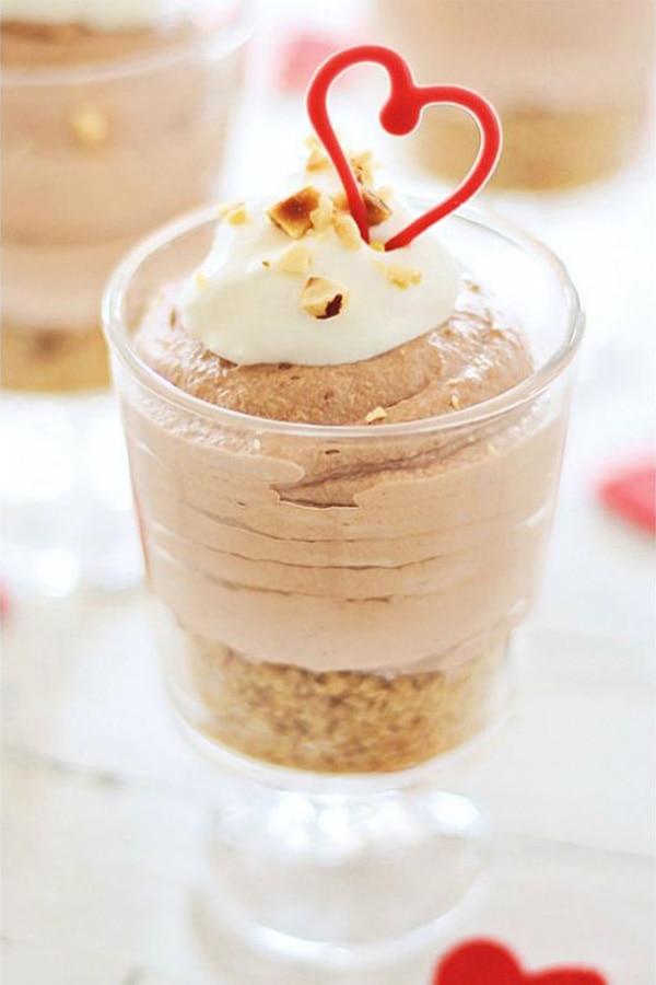 Easy and delicious homemade Nutella cheesecake mousse in a glass, with hazelnuts.