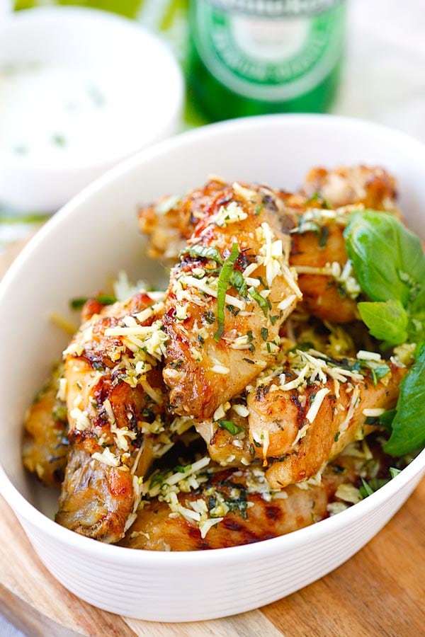 Quick and easy baked chicken wings with Parmesan cheese, garlic, basil, and spices, with blue cheese mustard dressing in a serving dish.