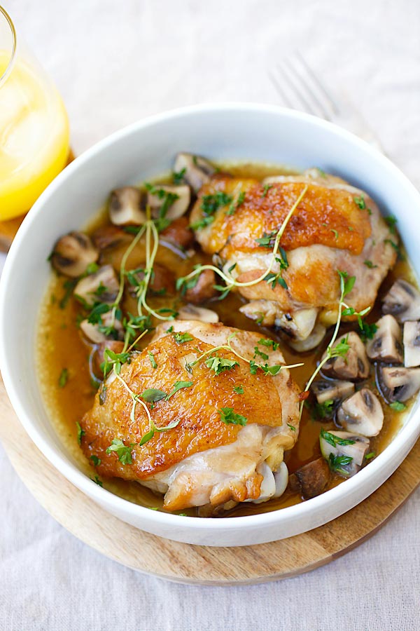 Easy and quick one-pan chicken with mushroom, with wine and chicken broth in a serving dish.