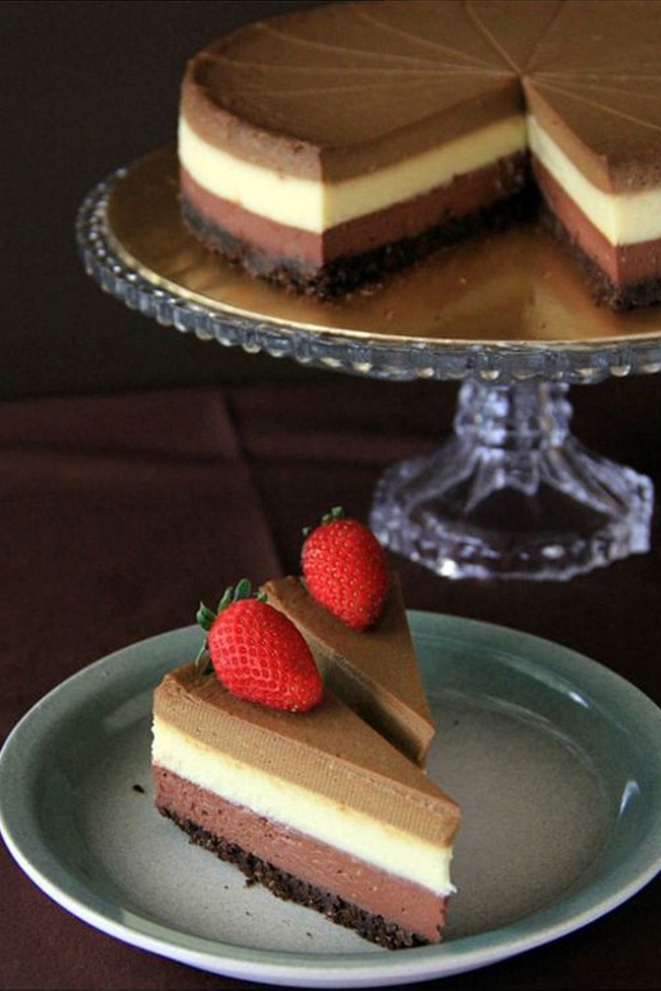 Easy and quick homemade triple layer cheesecake, topped with fresh strawberries, ready to serve.