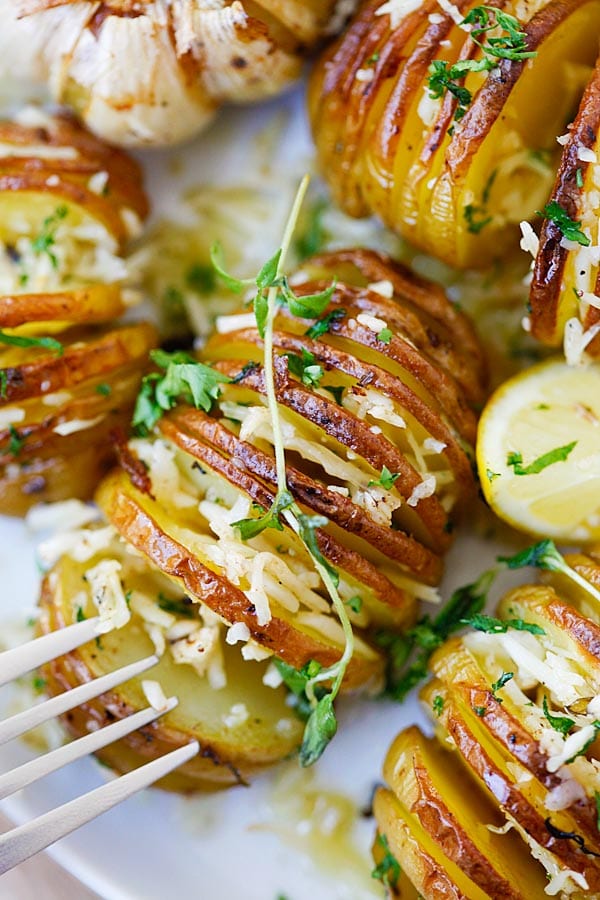 Roasted potatoes with Parmesan cheese, butter and herbs in a plate ready to serve.