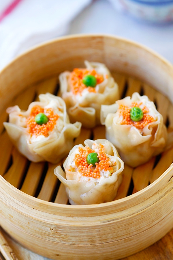 Chicken Shu Mai (Siu Mai) topped with tobiko and peas in a bamboo steamer.