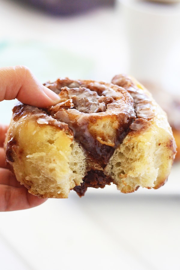 Easy and quick homemade pizza dough cinnamon rolls held in hands.