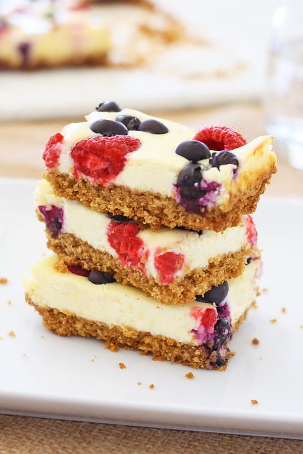 Healthy homemade berry cheesecake bars dessert topped with fresh berries, ready to serve.