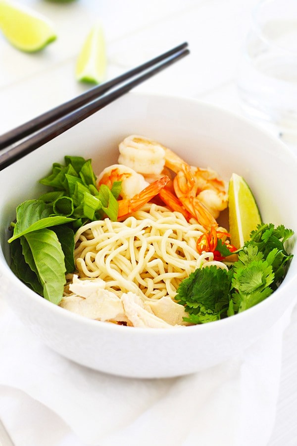 Coconut Curry Noodle Bowl topped with chicken, shrimp, & herbs.