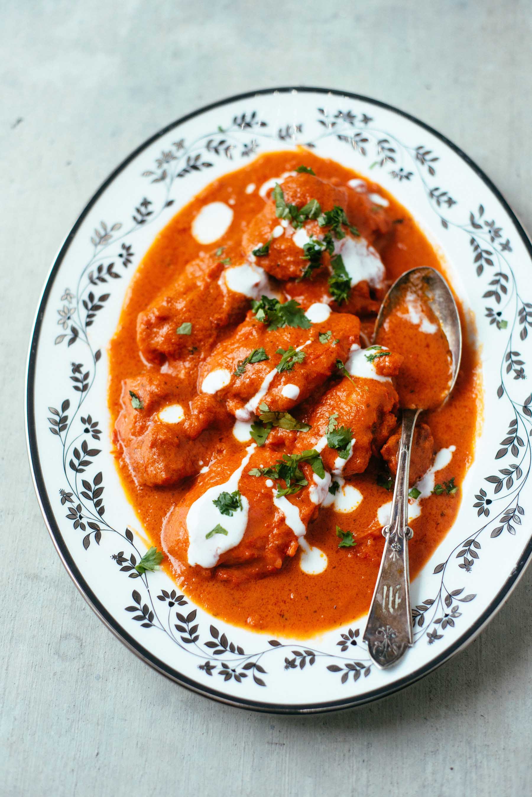Indian butter chicken in a rich and creamy sauce and topped with cilantro and heavy cream.
