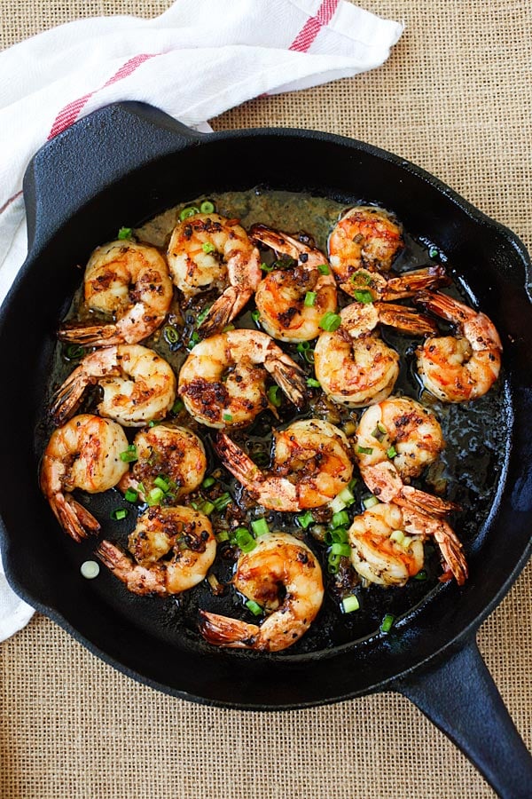 Black pepper shrimp pan-fried to perfection with scallions in a skillet.