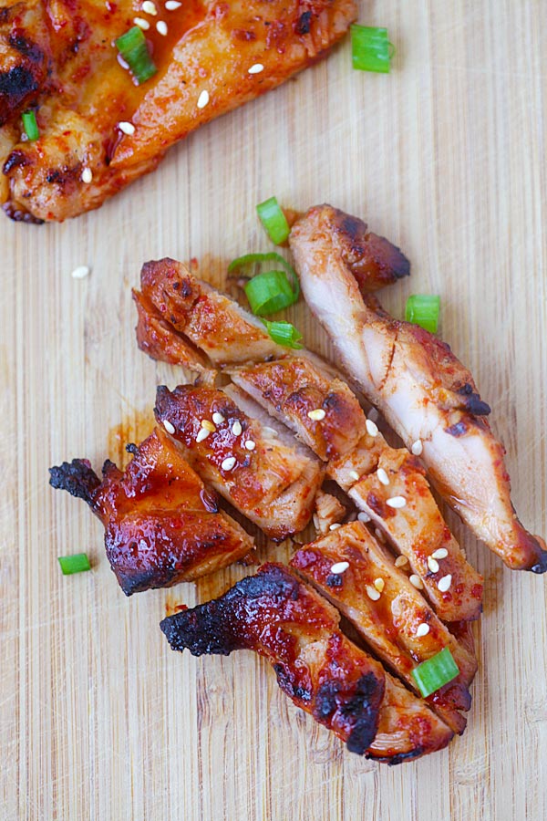 Slicing Korean chicken on a chopping board. 