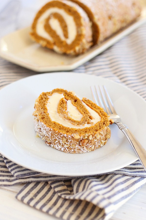 Easy and delicious homemade fall season pumpkin roll cake, served in a dessert plate with a fork.
