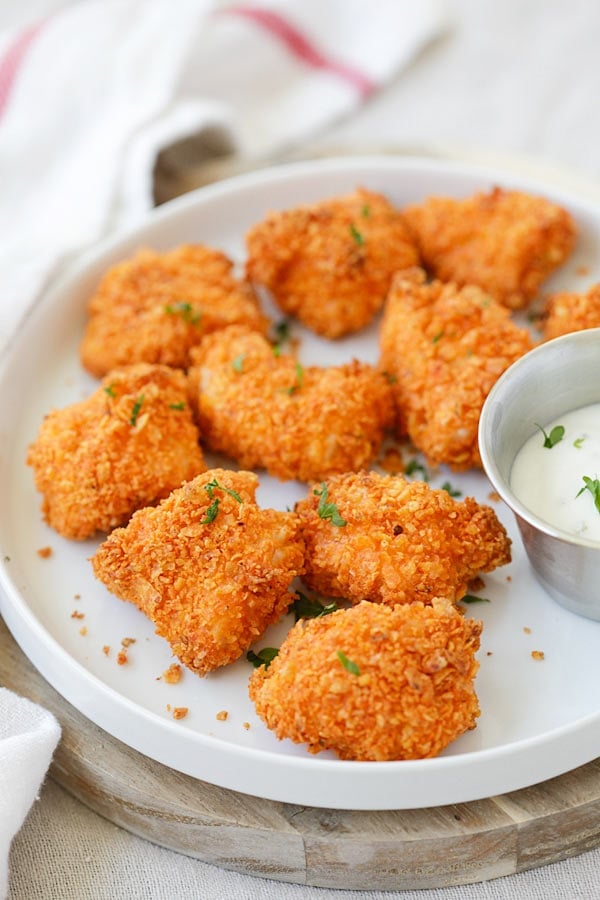 Baked crispy tortilla chips chicken bites on a plate.