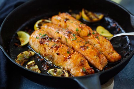 Cooked honey gaarlic salmon in a skillet.
