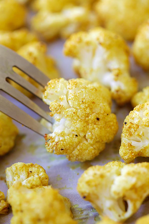 Easy and quick healthy oven roasted curry cauliflower pick with a fork.