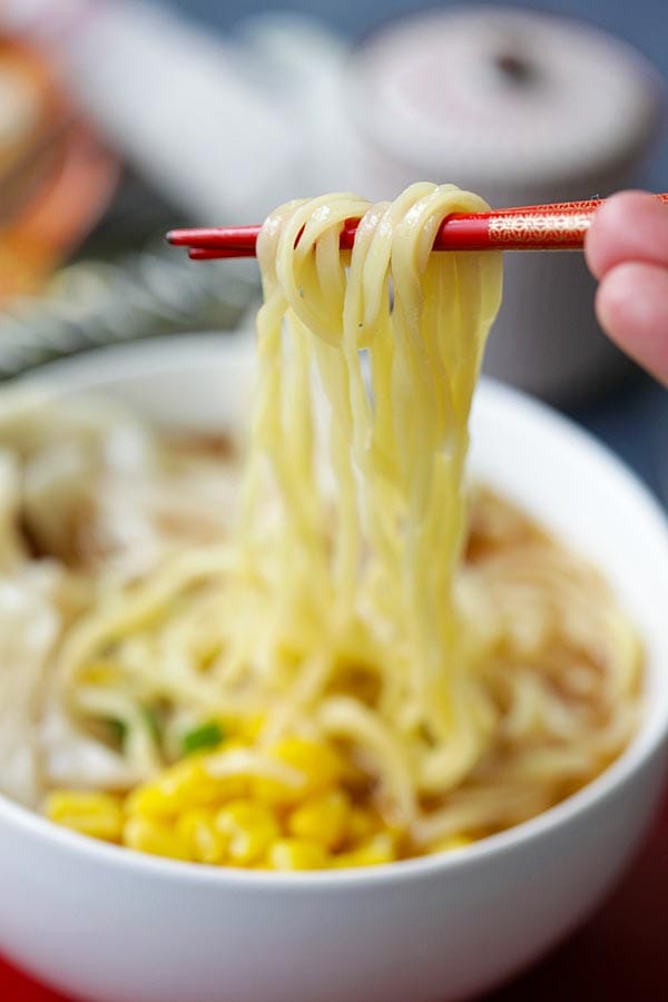 Easy homemade Shrimp Wonton Miso Ramen with chopsticks picking up some chewy Nissin RAOH ramen.