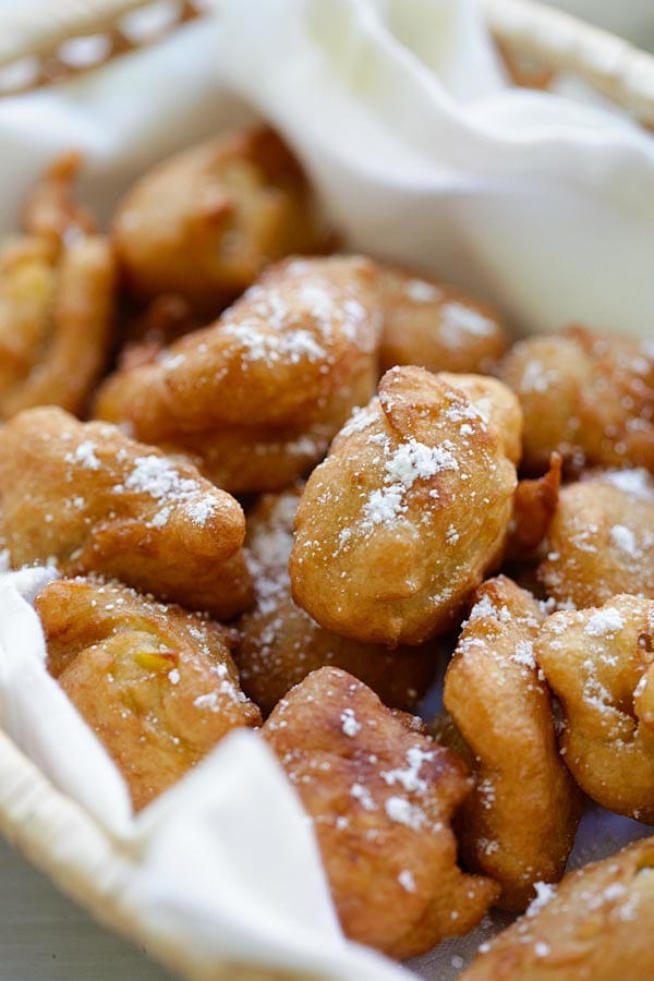 Sweet Corn Fritters dusted with powdered sugar served in a basket.