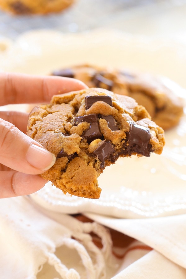 Delicious chewy peanut butter dark chocolate cookies held in hand.