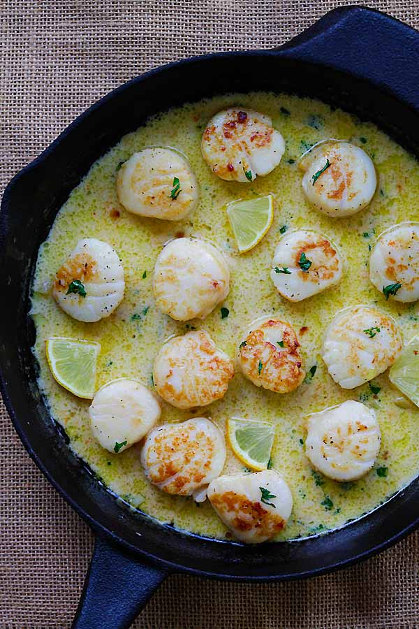 Easy and quick creamy garlic scallops in a skillet, ready to serve.