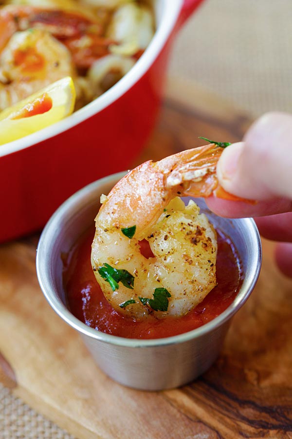Garlic herb roasted shrimp dipped into a side of dipping sauce.