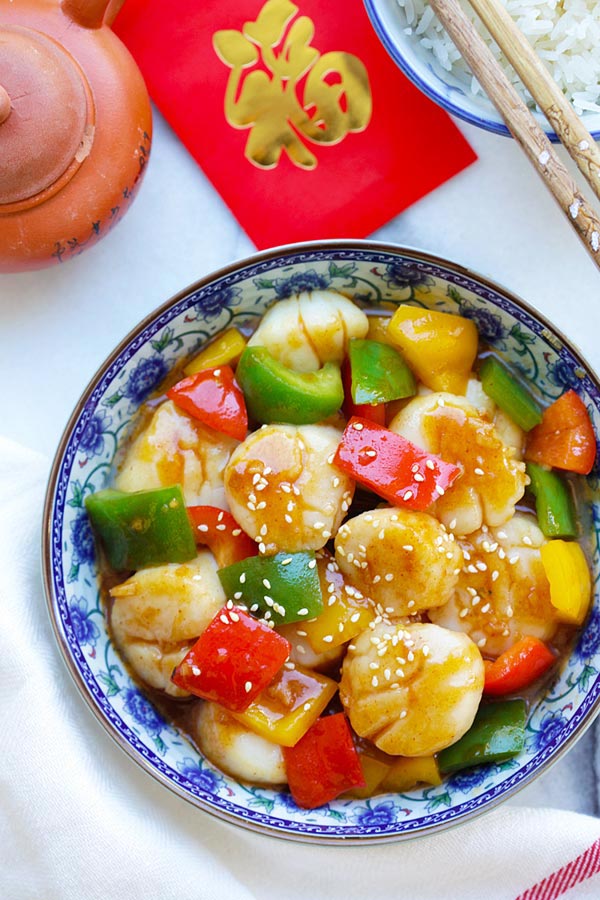 Easy and quick Szechuan scallops stir fry with fiery Szechuan sauce and bell peppers serve in a plate.