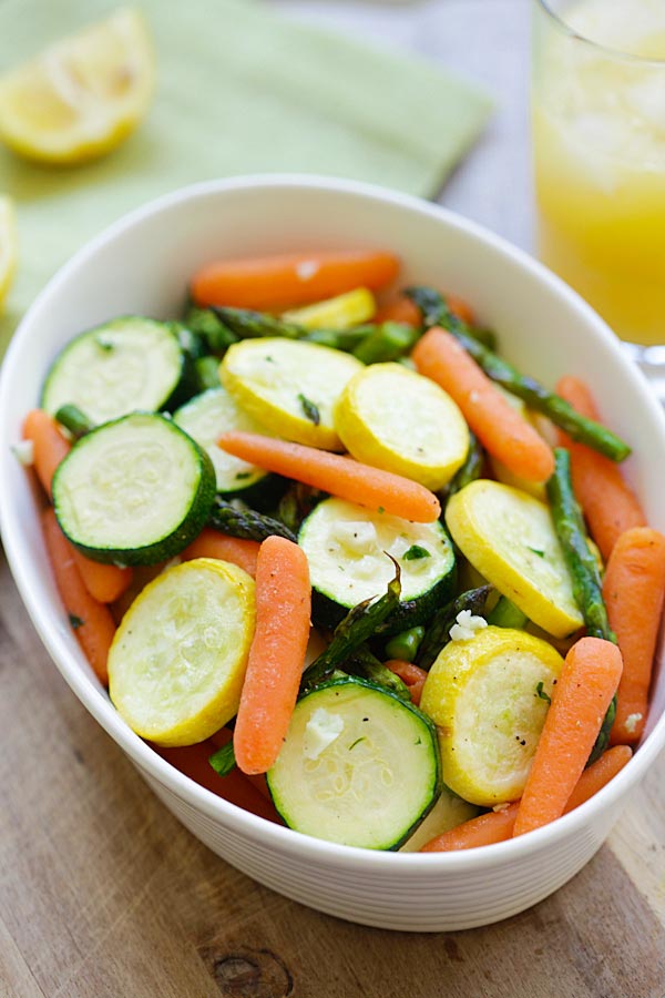 Easy and healthy roasted spring vegetables with garlic herb butter in a serving dish.