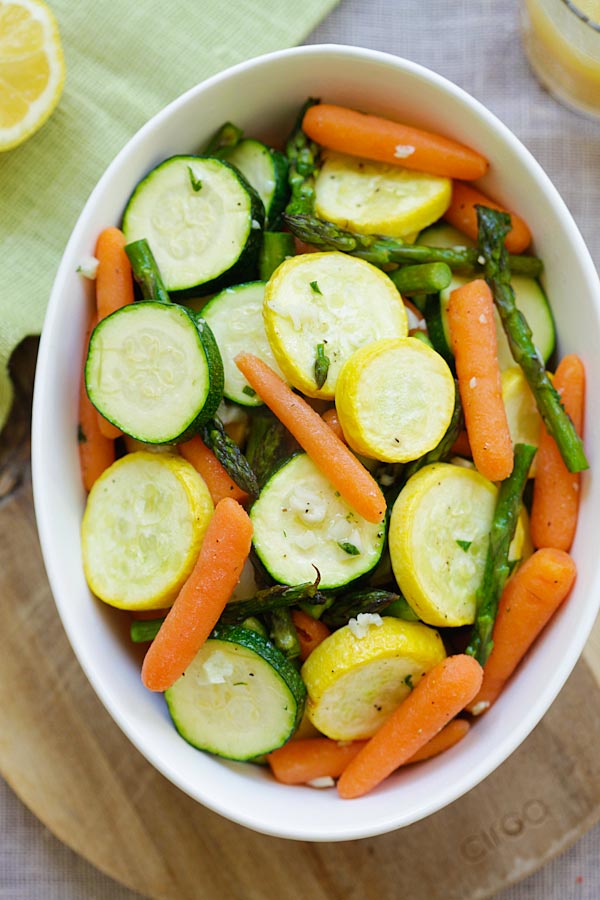 Roasted healthy spring salad that consists of asparagus, baby carrots, yellow squash, zucchini.