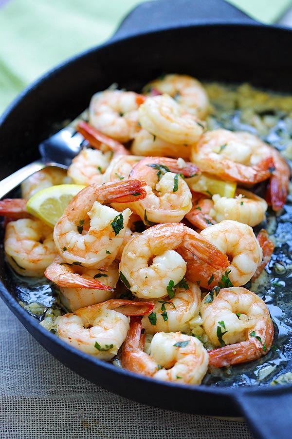 Shrimp scampi sauteed with garlic butter in skillet.