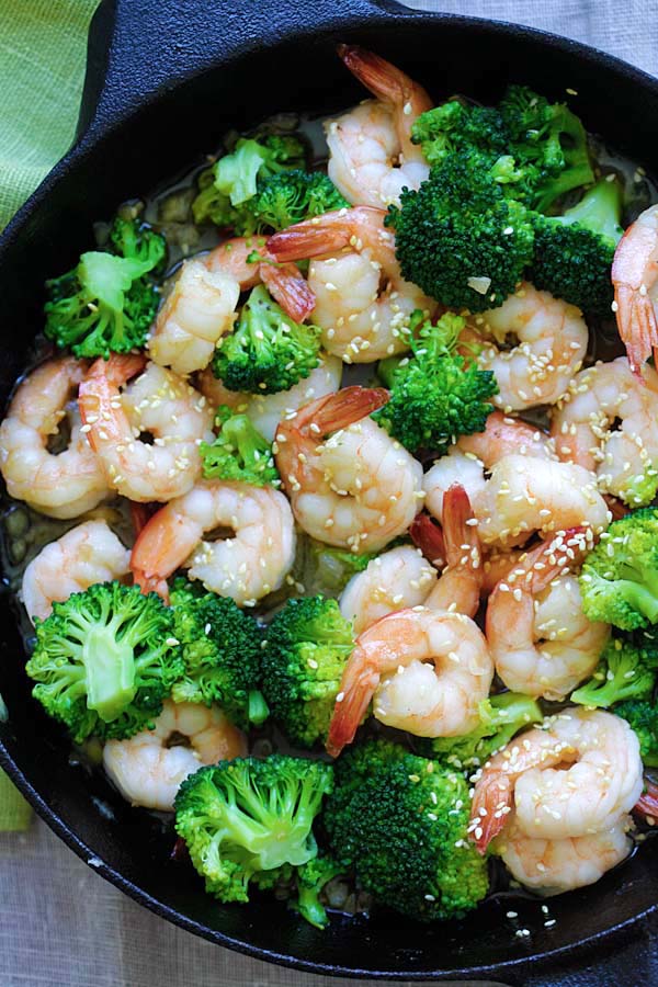 Easy and healthy shrimp stir-fry with broccoli in honey sesame sauce in a skillet.