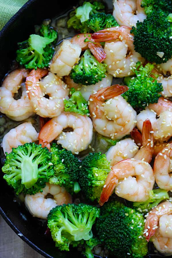 Stir fry broccoli in honey sesame sauce garnished with sesame seeds, ready to serve.