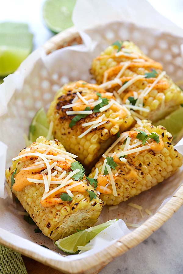 Mexi-Cali street corn with Chipotle seasoning, spicy mayo, Parmesan cheese, lime and cilantro in a basket.