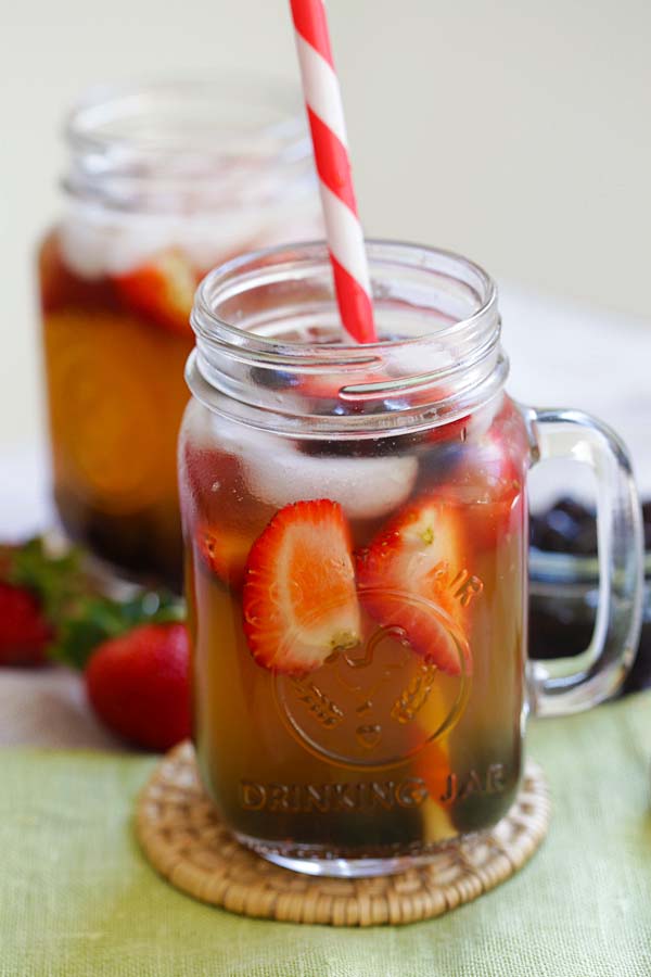 Asian style healthy homemade summer iced green tea with strawberry and tapioca pearl boba.